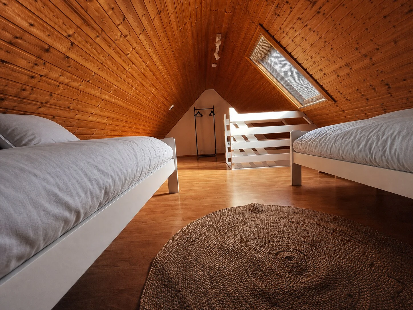 Zweites Schlafzimmer mit zwei bezogenen Einzelbetten in ruhigen Grau- und Weißtönen