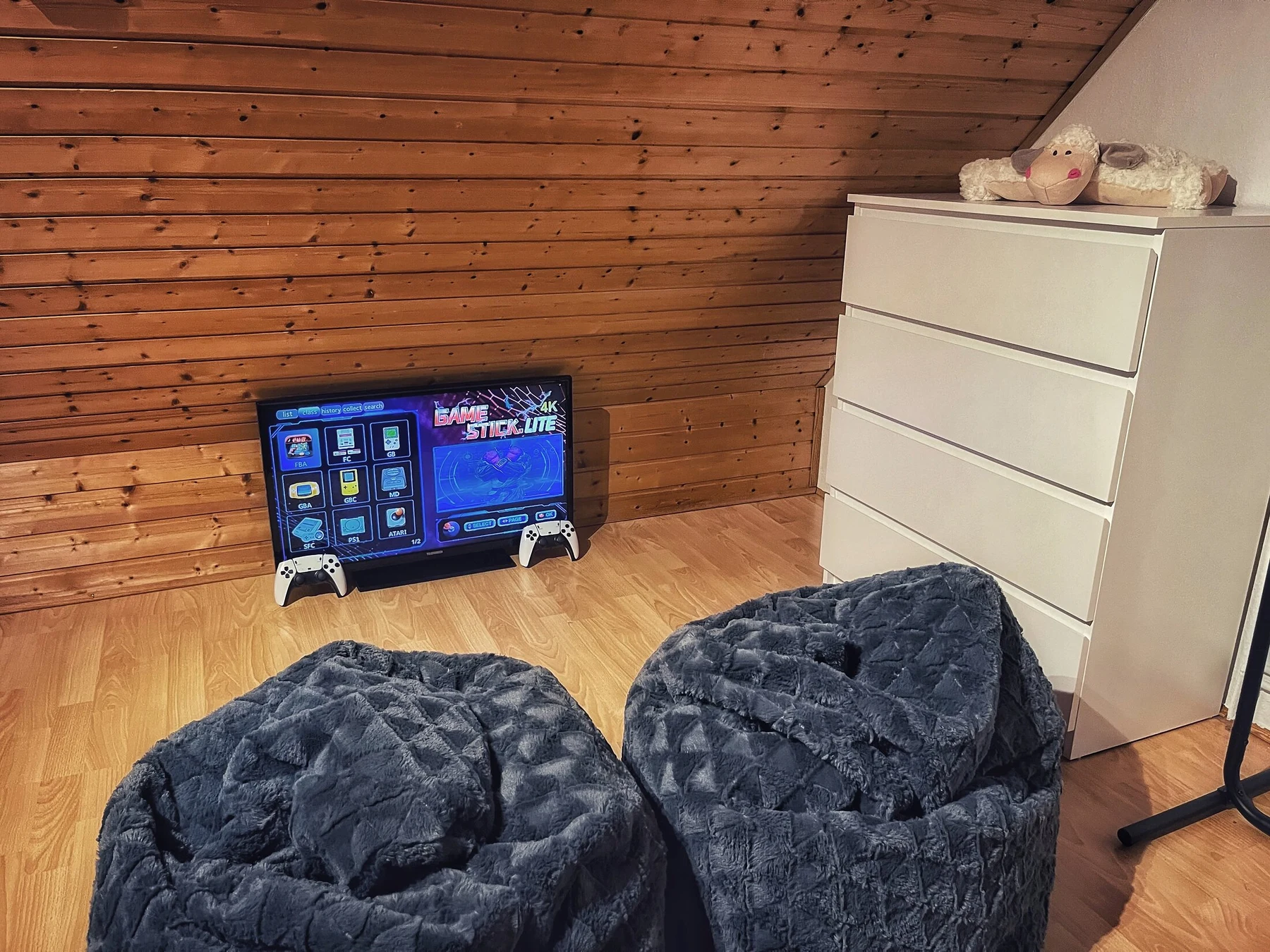 Dachstudio mit Sitzsäcken, Retro-Konsole, TV und weißer Kommode